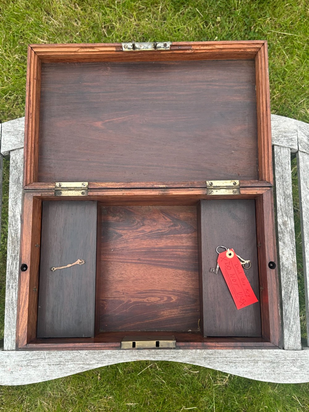 A rectangular reddish-brown padouk wood deed box featuring brass corner mounts, a central keyhole escutcheon, and brass side carrying handles. View II