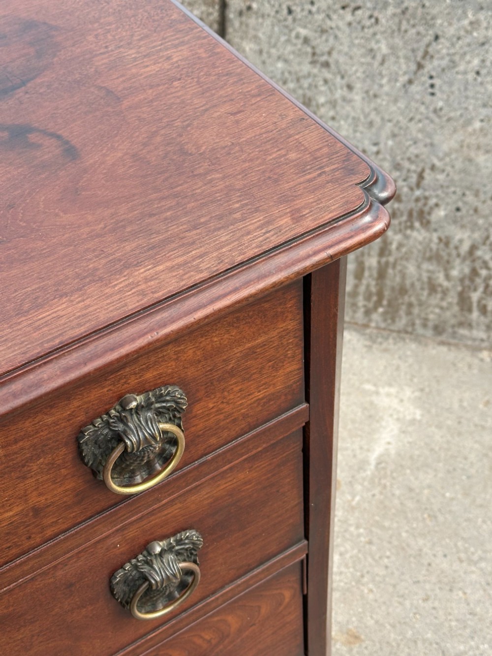 A late eighteenth-century George III mahogany chest of drawers with four graduating drawers, brass ring handles, keyhole escutcheons, and bracket feet. View III