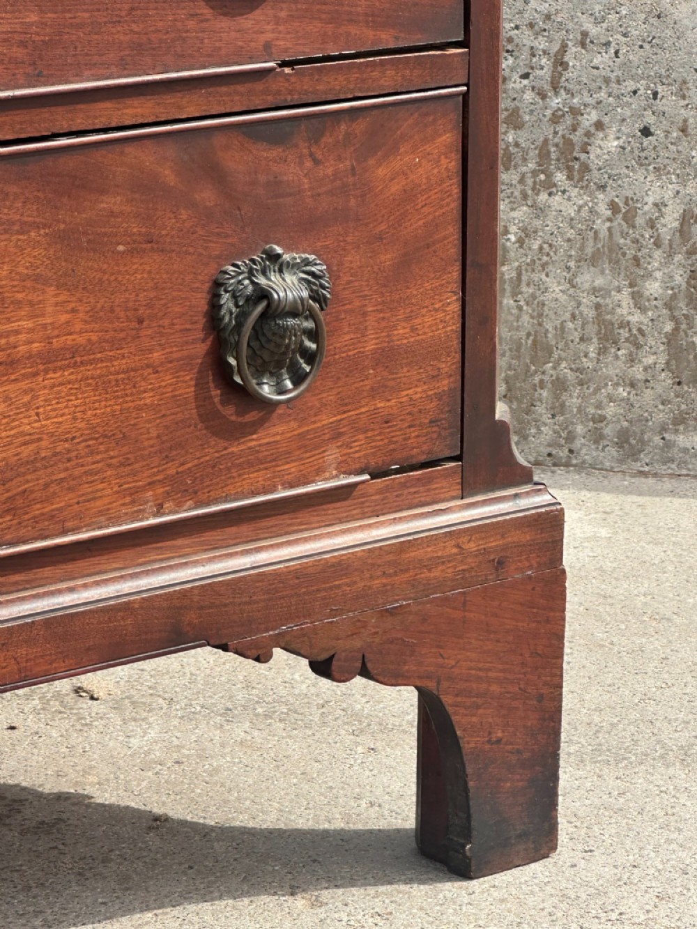 A late eighteenth-century George III mahogany chest of drawers with four graduating drawers, brass ring handles, keyhole escutcheons, and bracket feet. View VIII