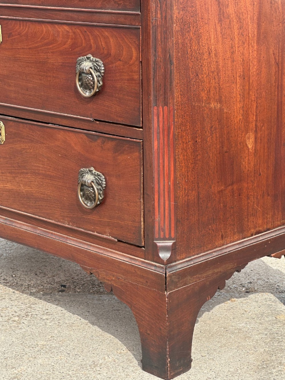 A late eighteenth-century George III mahogany chest of drawers with four graduating drawers, brass ring handles, keyhole escutcheons, and bracket feet. View XIII
