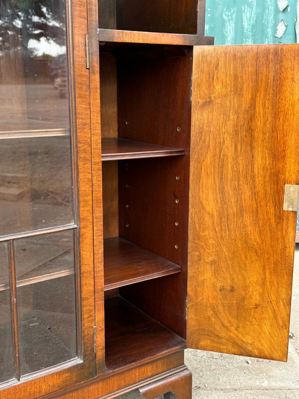 An architectural 1930s Art Deco cabinet made of warm brown walnut wood with a tall central glazed door flanked by lower cupboard doors and open alcoves. View V