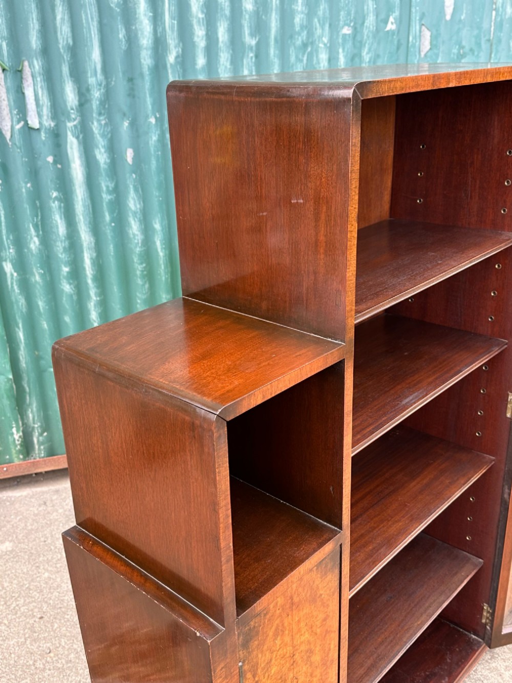 An architectural 1930s Art Deco cabinet made of warm brown walnut wood with a tall central glazed door flanked by lower cupboard doors and open alcoves. View VII