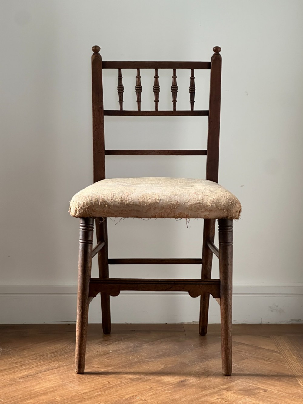 A 19th-century Sussex style side chair featuring turned spindles in the backrest, a dark wood frame, and a padded upholstered seat. View II