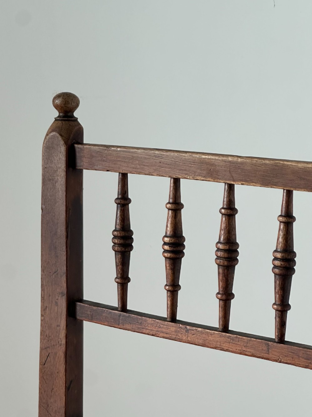 A 19th-century Sussex style side chair featuring turned spindles in the backrest, a dark wood frame, and a padded upholstered seat. View III