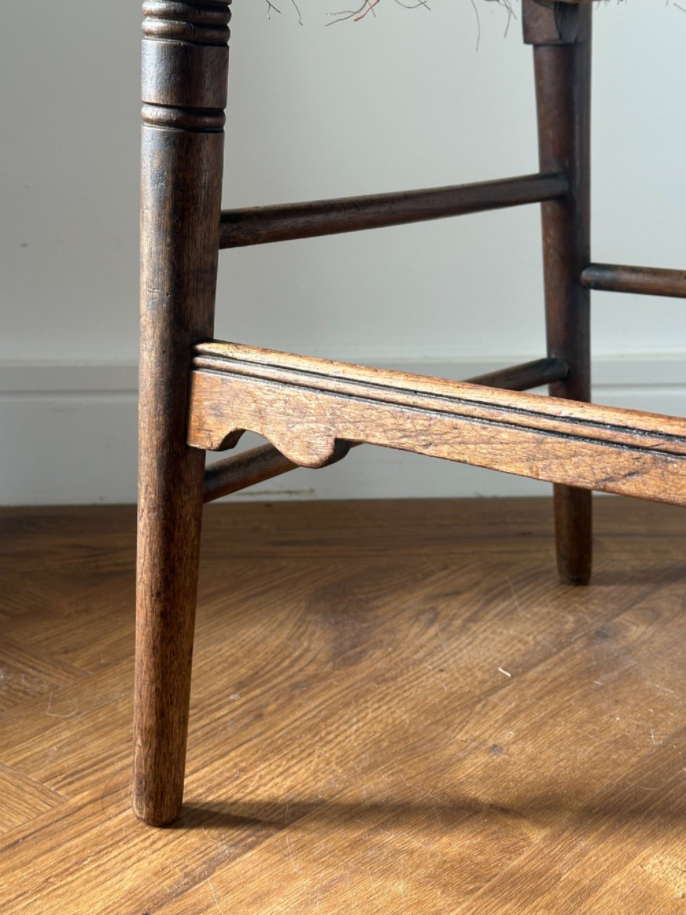 A 19th-century Sussex style side chair featuring turned spindles in the backrest, a dark wood frame, and a padded upholstered seat. View IV