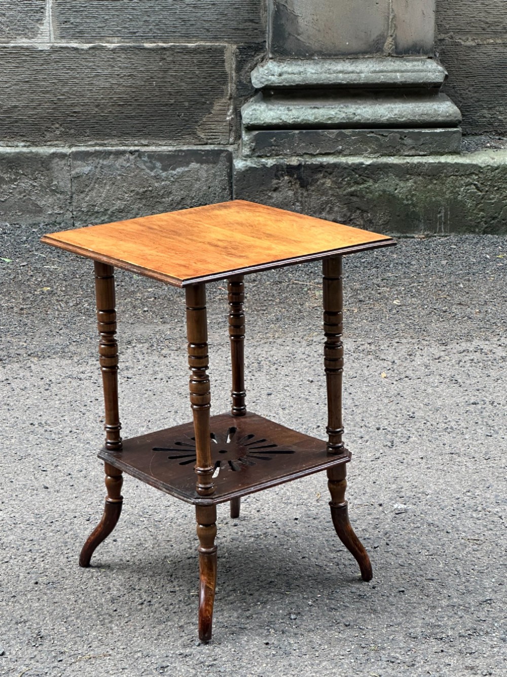 An Anglo-Japanese two-tier wooden occasional table featuring turned spindle legs, a square top, and a pierced lower shelf. View II