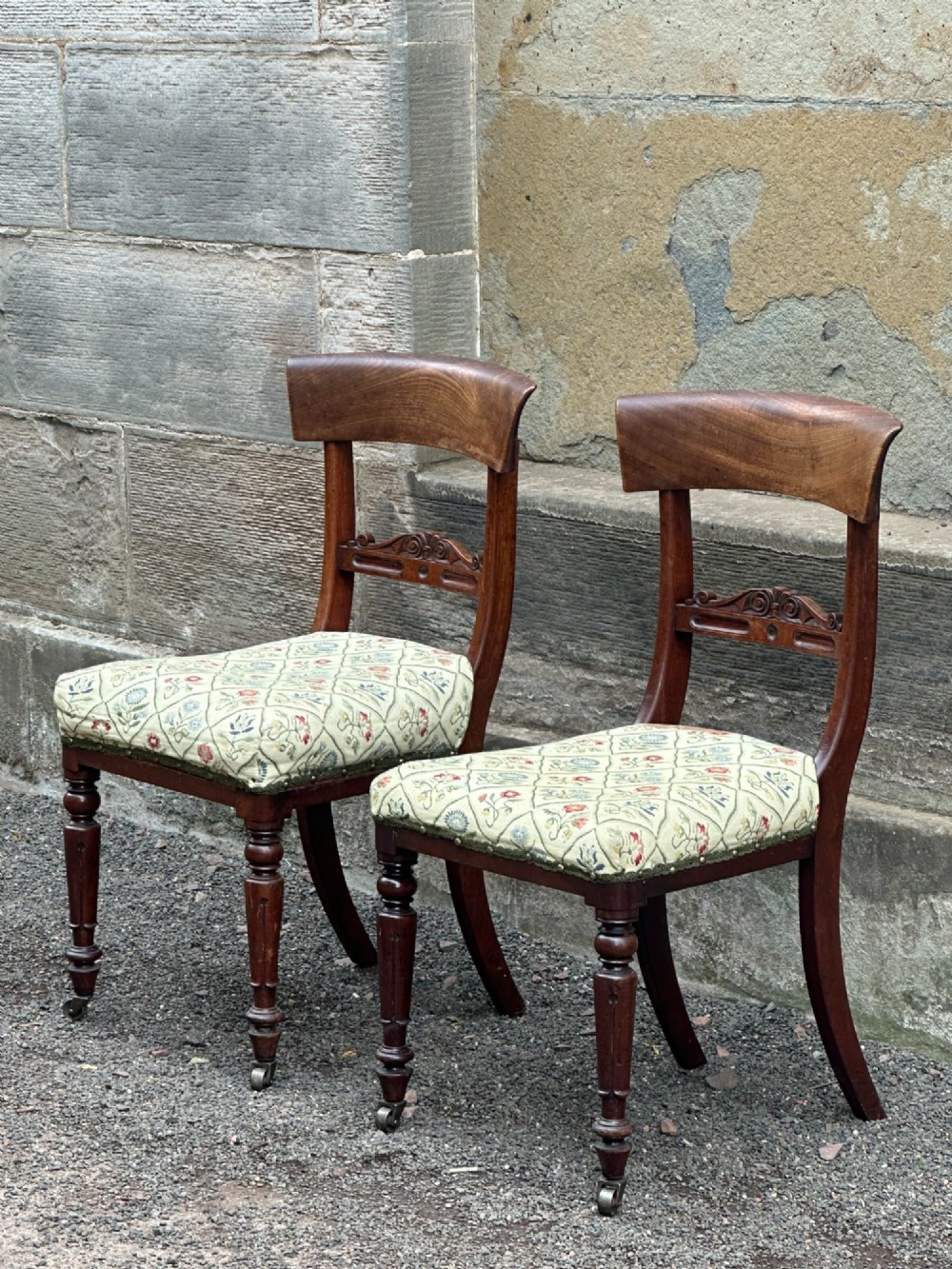 A pair of Scottish Regency mahogany side chairs with curved top rails, carved back splats, upholstered seats, and turned front legs on castors. View III