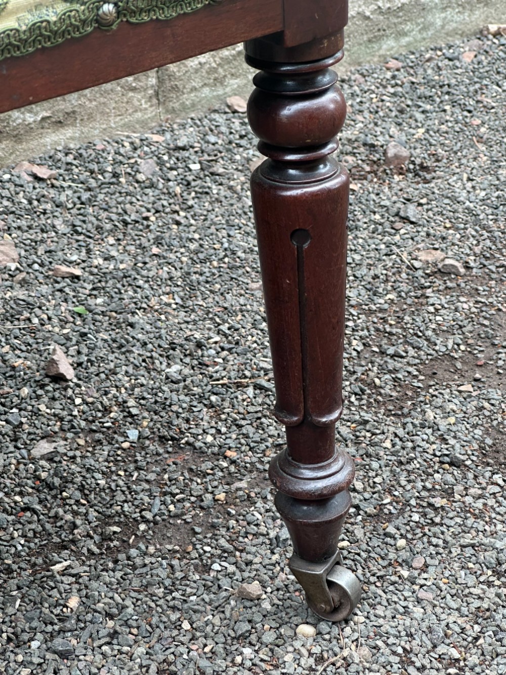 A pair of Scottish Regency mahogany side chairs with curved top rails, carved back splats, upholstered seats, and turned front legs on castors. View V