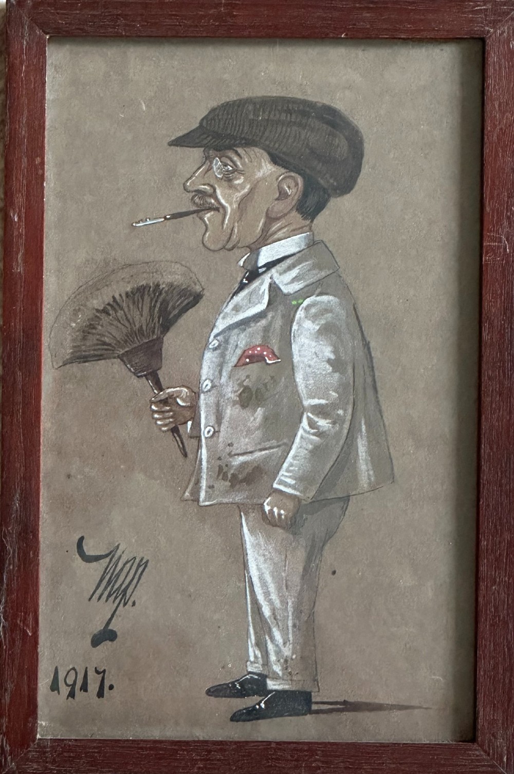 A framed 1917 caricature drawing on paper depicting a profile view of a gentleman in a flat cap holding a hand fan.