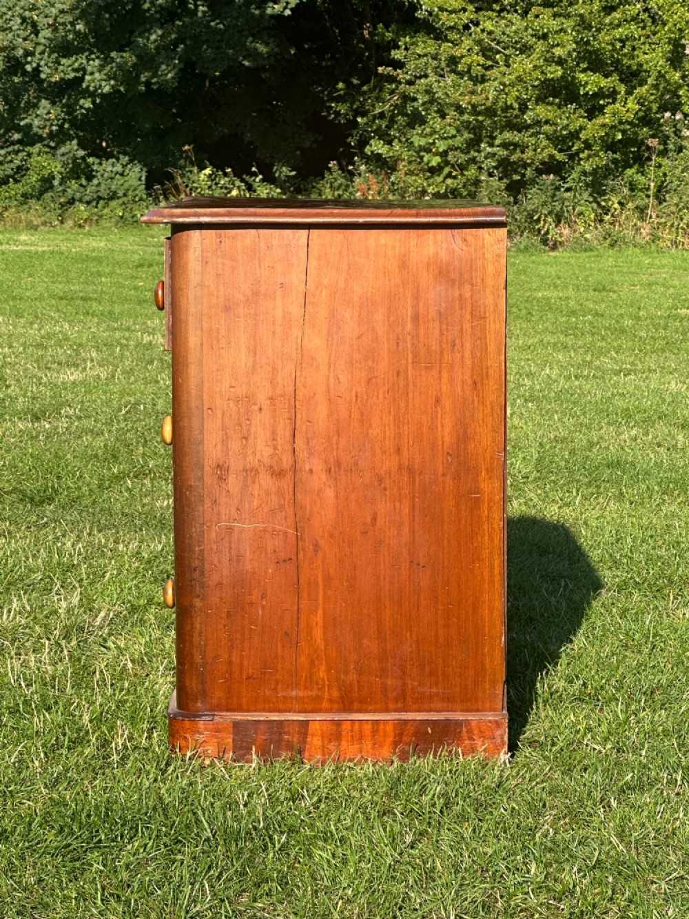 A small Victorian flame mahogany Scotch chest of drawers with two short over two long drawers, turned wooden knobs, and a serpentine top. View VI
