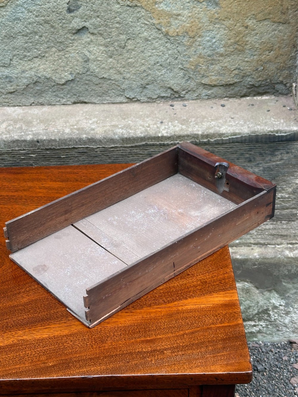 A George III mahogany side table with tapered legs, a flame mahogany veneered frieze, and a brass drawer pull. View V