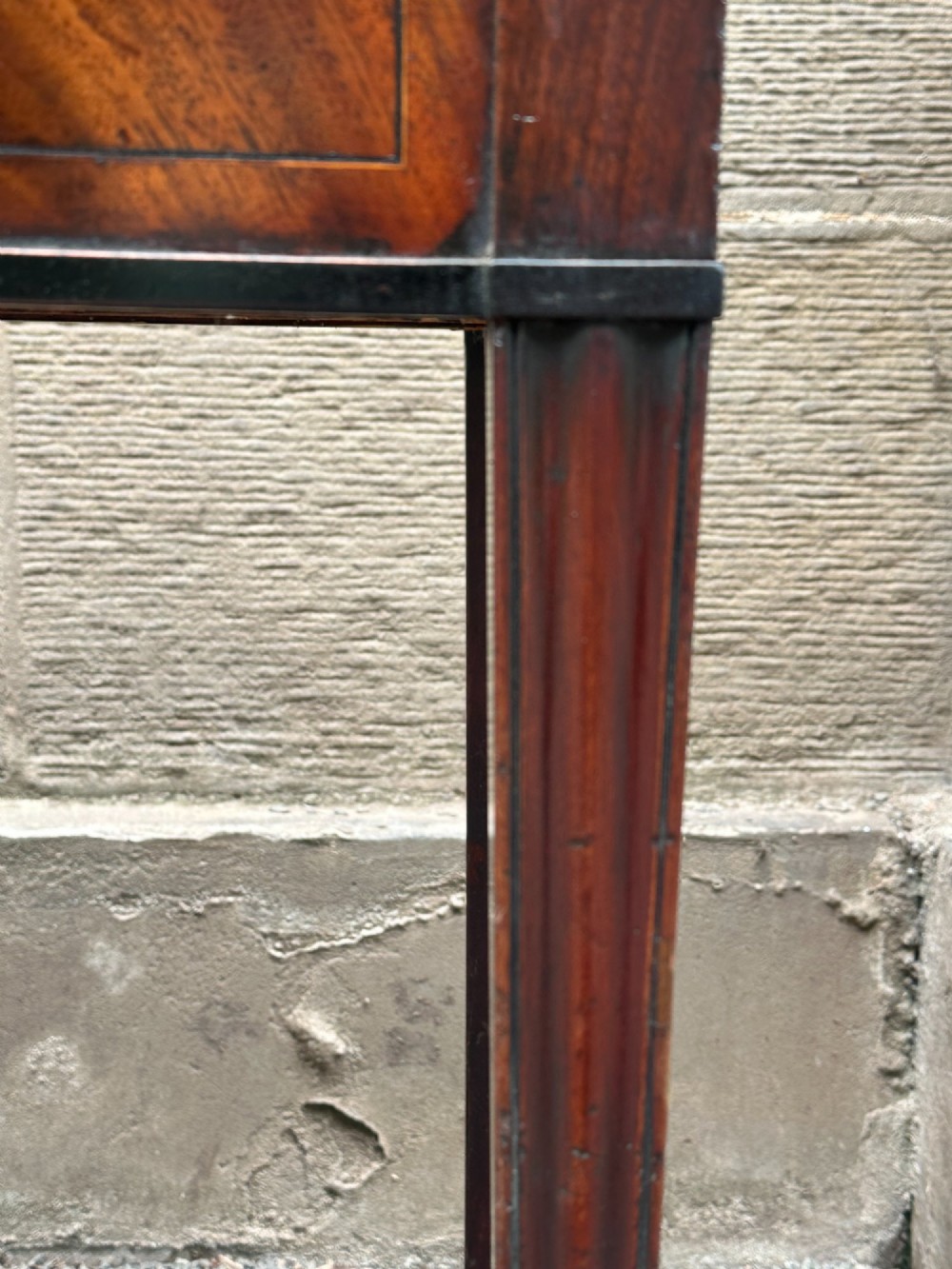 A George III mahogany side table with tapered legs, a flame mahogany veneered frieze, and a brass drawer pull. View XI