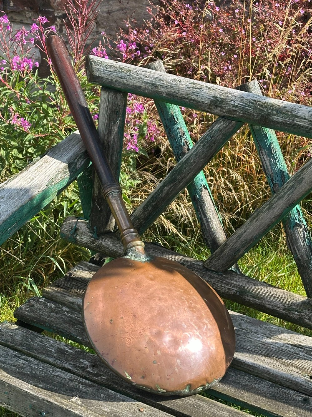 A circular Georgian copper moon flask with a threaded top loop, displayed alongside a separate turned dark oak handle. View II