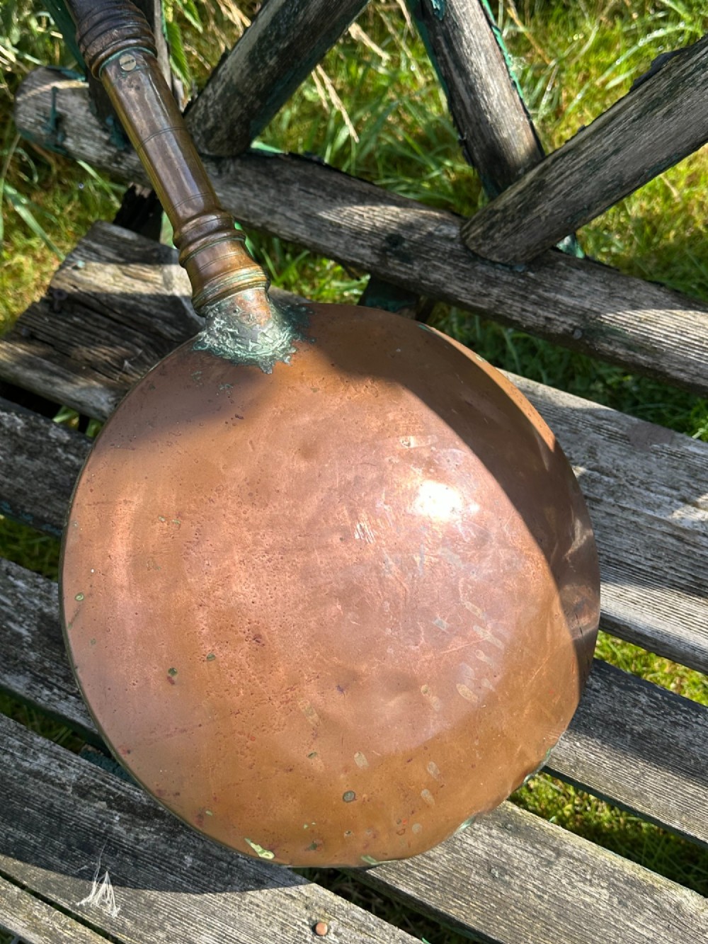 A circular Georgian copper moon flask with a threaded top loop, displayed alongside a separate turned dark oak handle. View III