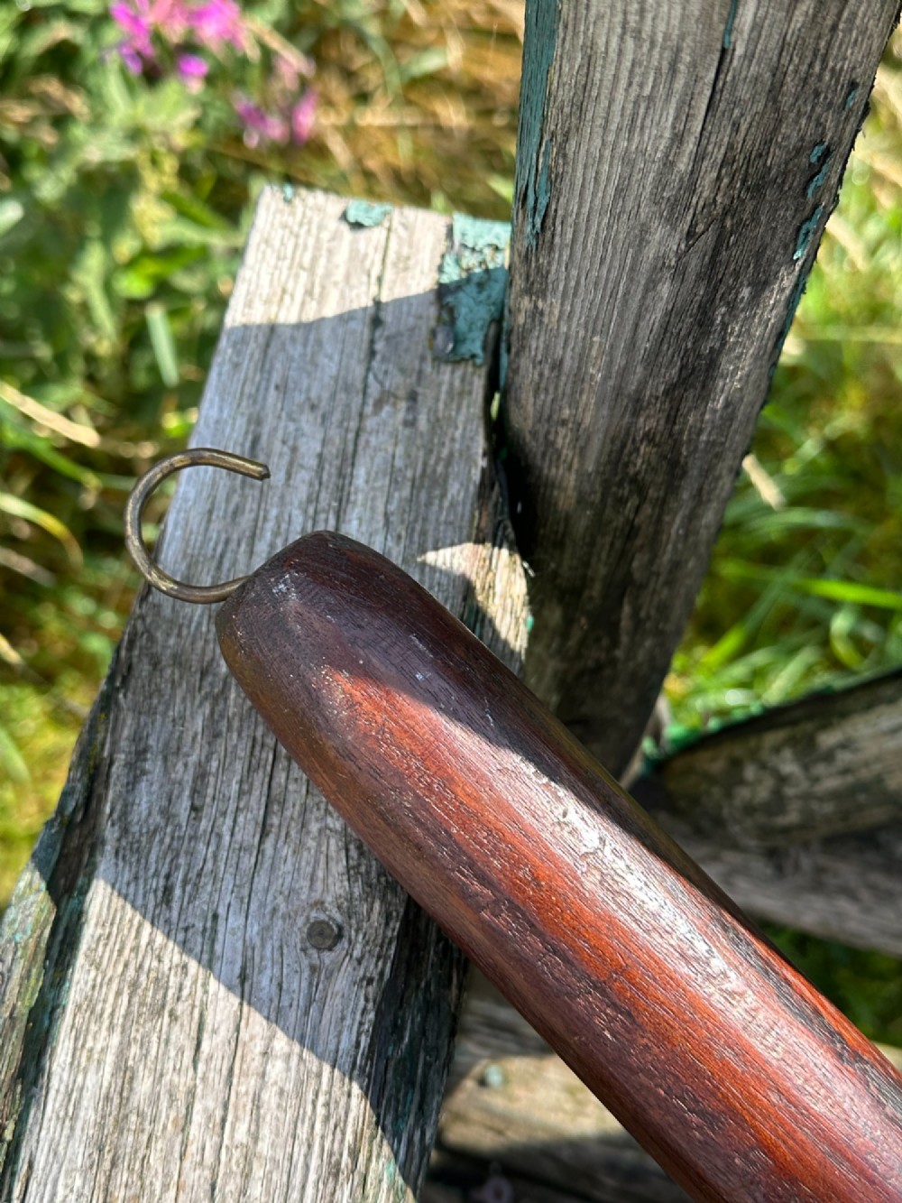 A circular Georgian copper moon flask with a threaded top loop, displayed alongside a separate turned dark oak handle. View IV
