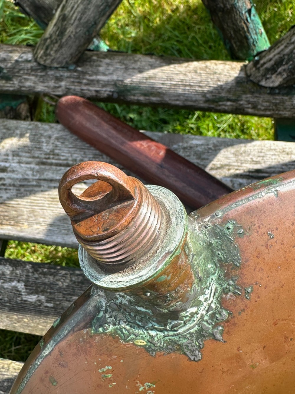 A circular Georgian copper moon flask with a threaded top loop, displayed alongside a separate turned dark oak handle. View VII