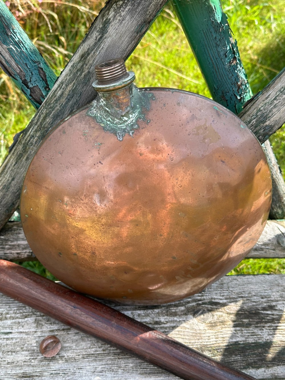 A circular Georgian copper moon flask with a threaded top loop, displayed alongside a separate turned dark oak handle. View VIII