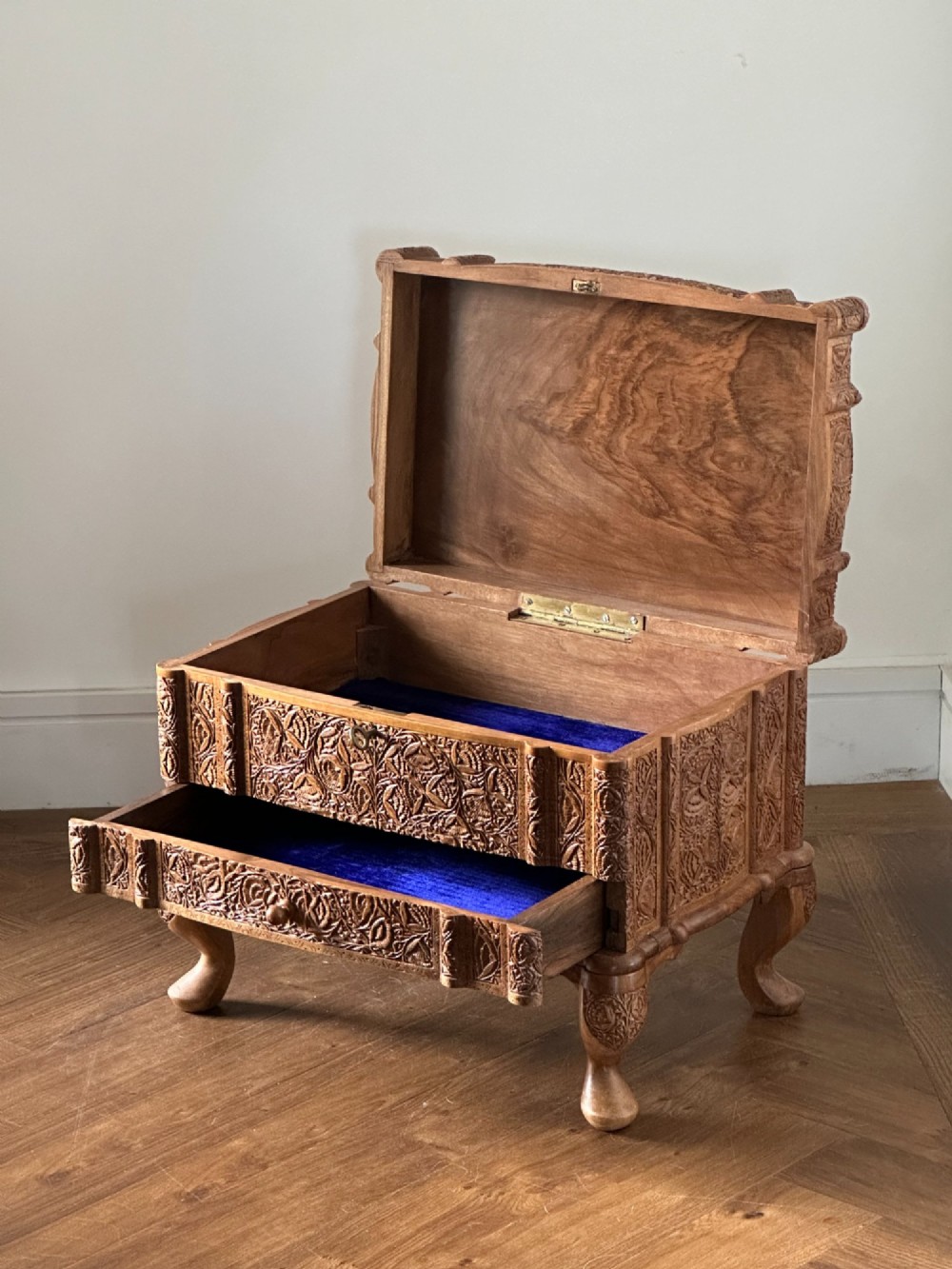 An intricately carved Anglo-Indian wooden jewellery casket featuring a sarcophagus-shaped lid and raised cabriole legs. View II