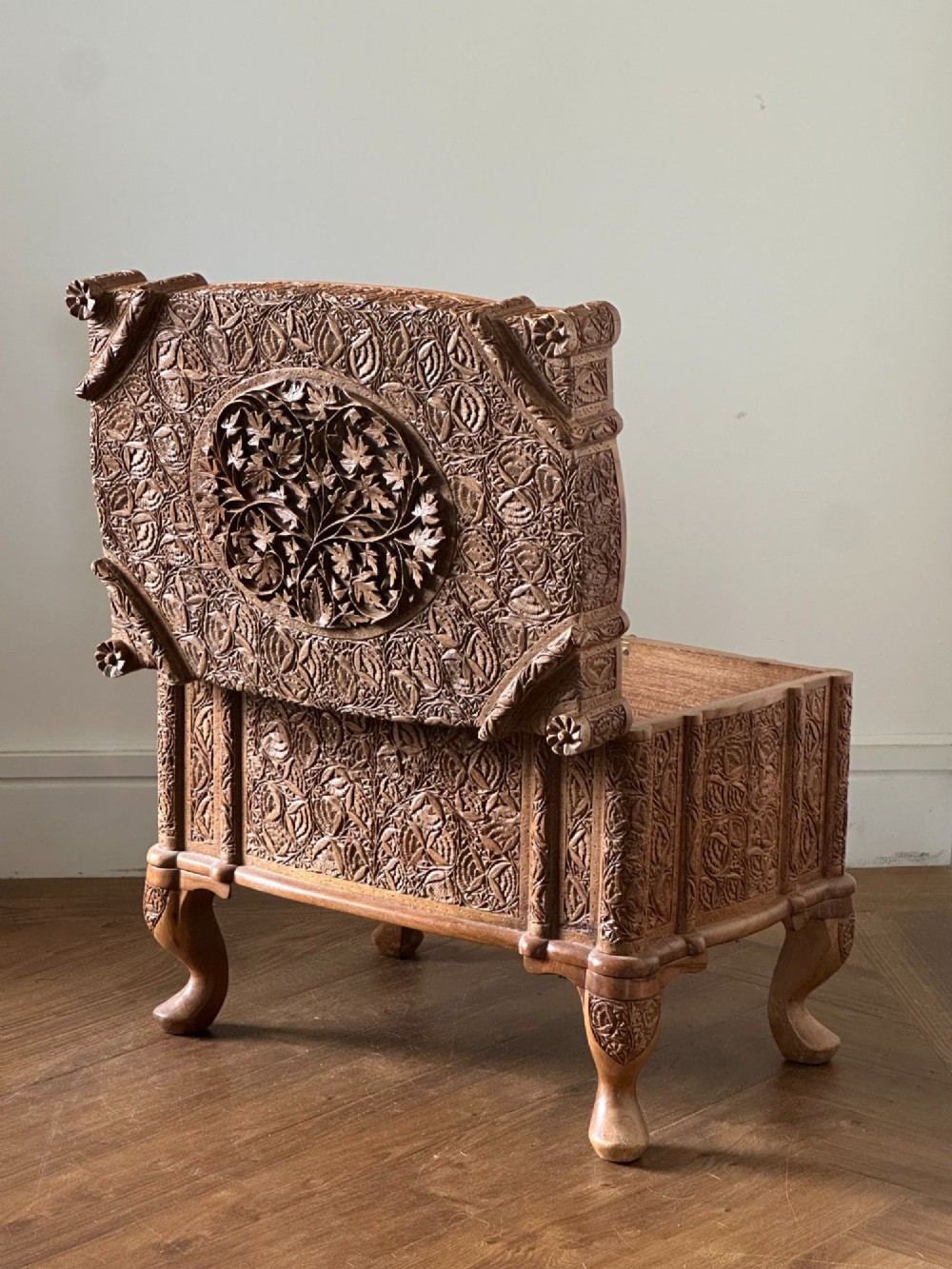 An intricately carved Anglo-Indian wooden jewellery casket featuring a sarcophagus-shaped lid and raised cabriole legs. View V