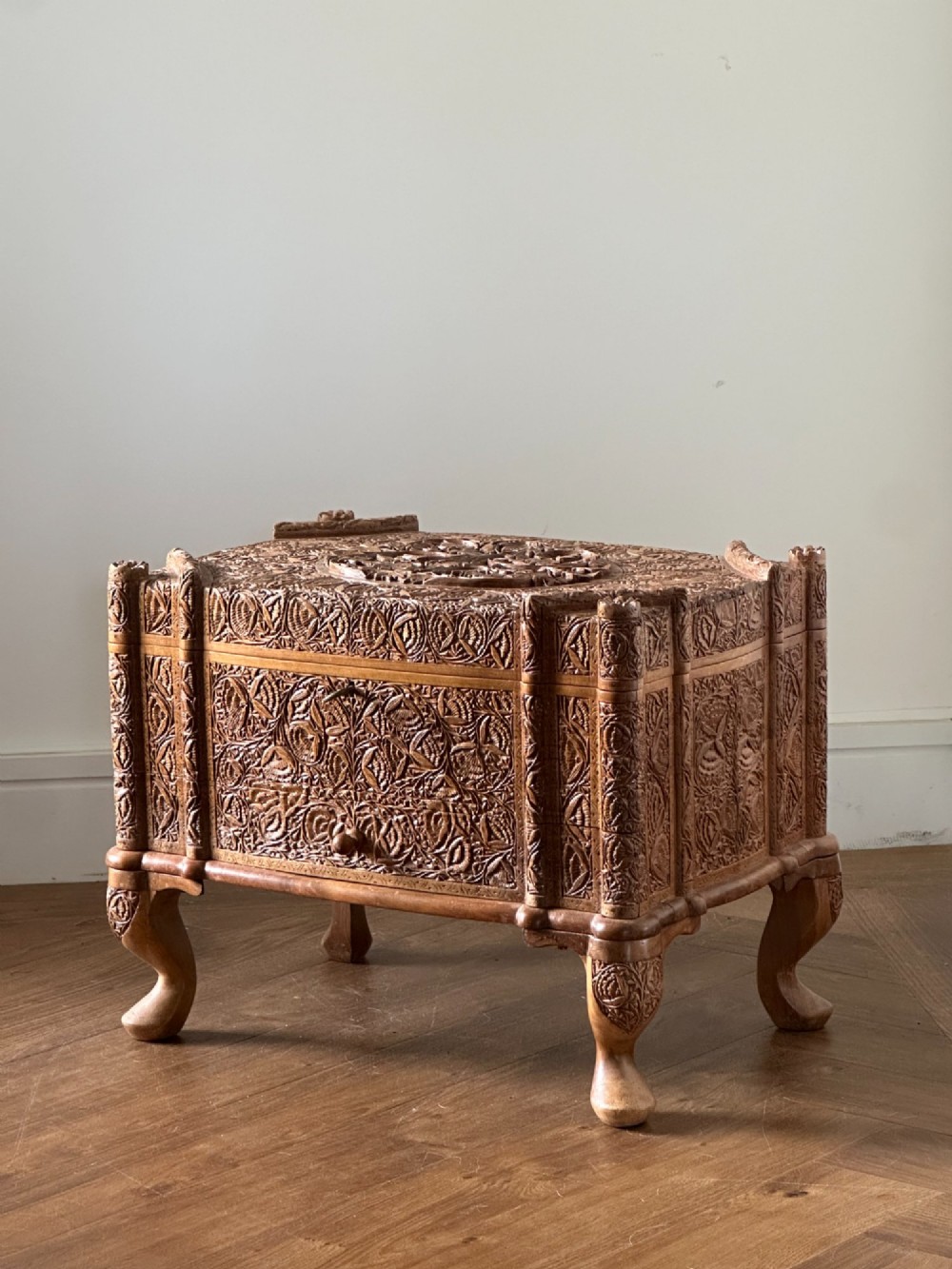 An intricately carved Anglo-Indian wooden jewellery casket featuring a sarcophagus-shaped lid and raised cabriole legs. View VI