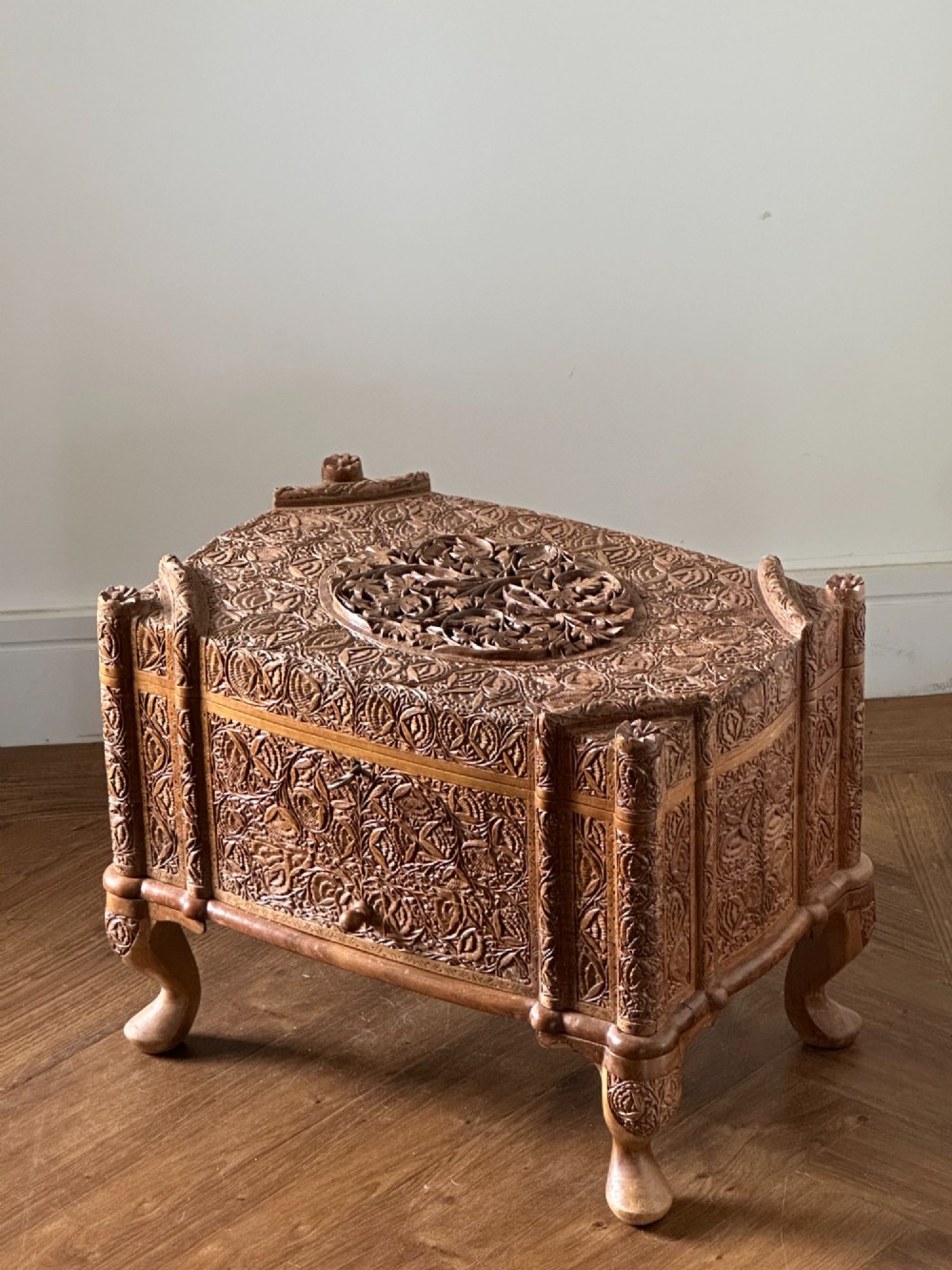 An intricately carved Anglo-Indian wooden jewellery casket featuring a sarcophagus-shaped lid and raised cabriole legs. View VII