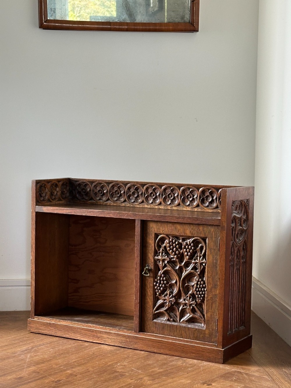 An Arts and Crafts carved oak table cabinet in the manner of Arthur Simpson of Kendal (1857-1922)