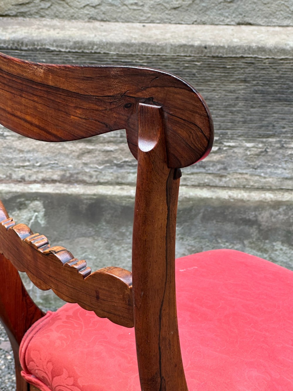 Set of six antique George IV rosewood dining chairs featuring carved top rails, horizontal back splats, turned front legs, and red upholstered seats. View VI