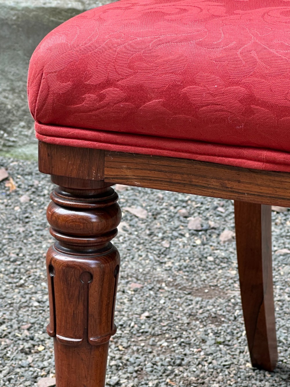 Set of six antique George IV rosewood dining chairs featuring carved top rails, horizontal back splats, turned front legs, and red upholstered seats. View VII