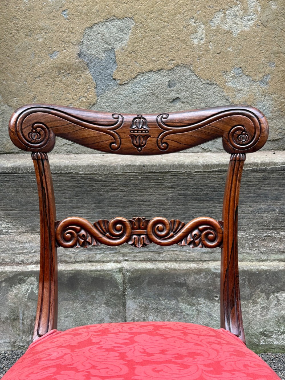 Set of six antique George IV rosewood dining chairs featuring carved top rails, horizontal back splats, turned front legs, and red upholstered seats. View IX