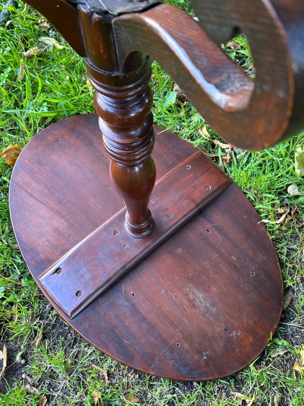 A George III mahogany tripod table featuring a circular top supported by a turned central stem and three scrolled legs. View IV