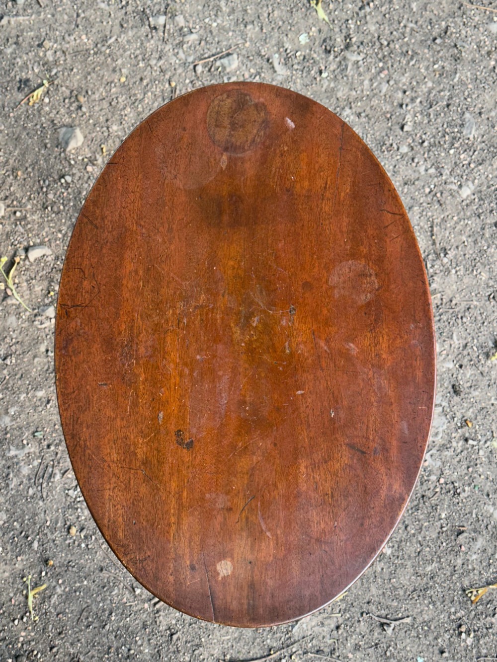 A George III mahogany tripod table featuring a circular top supported by a turned central stem and three scrolled legs. View VIII