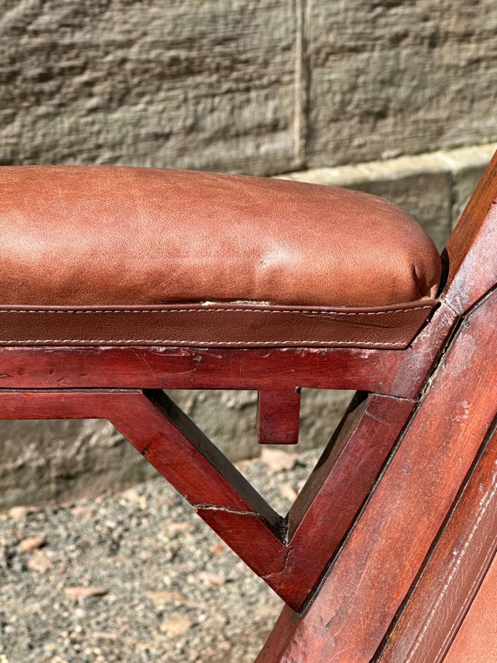 A pair of nineteenth-century Greek Revival mahogany armchairs upholstered in warm brown leather with turned front legs on castors and incised geometric detailing. View IV