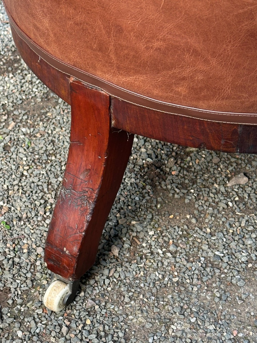 A pair of nineteenth-century Greek Revival mahogany armchairs upholstered in warm brown leather with turned front legs on castors and incised geometric detailing. View XIII