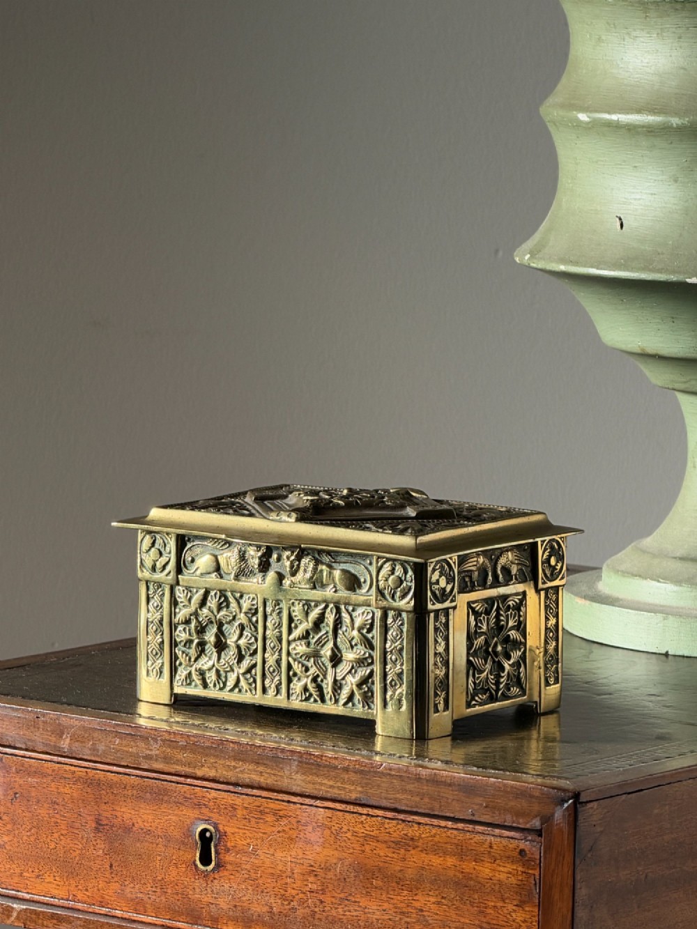 A nineteenth-century rectangular cast brass casket featuring detailed relief ornamentation of animals, foliage, and geometric patterns.