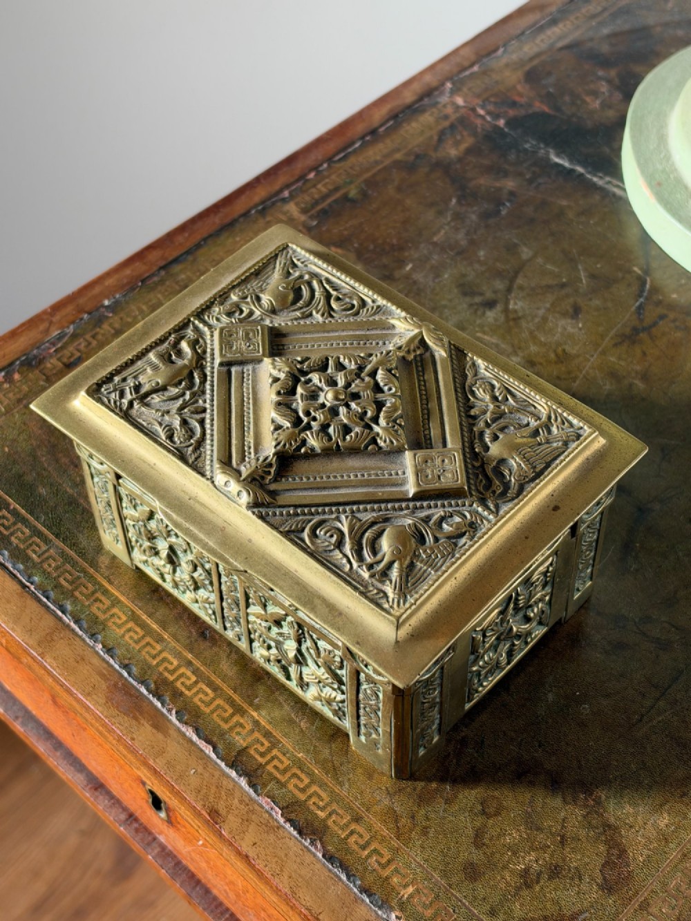 A nineteenth-century rectangular cast brass casket featuring detailed relief ornamentation of animals, foliage, and geometric patterns. View II