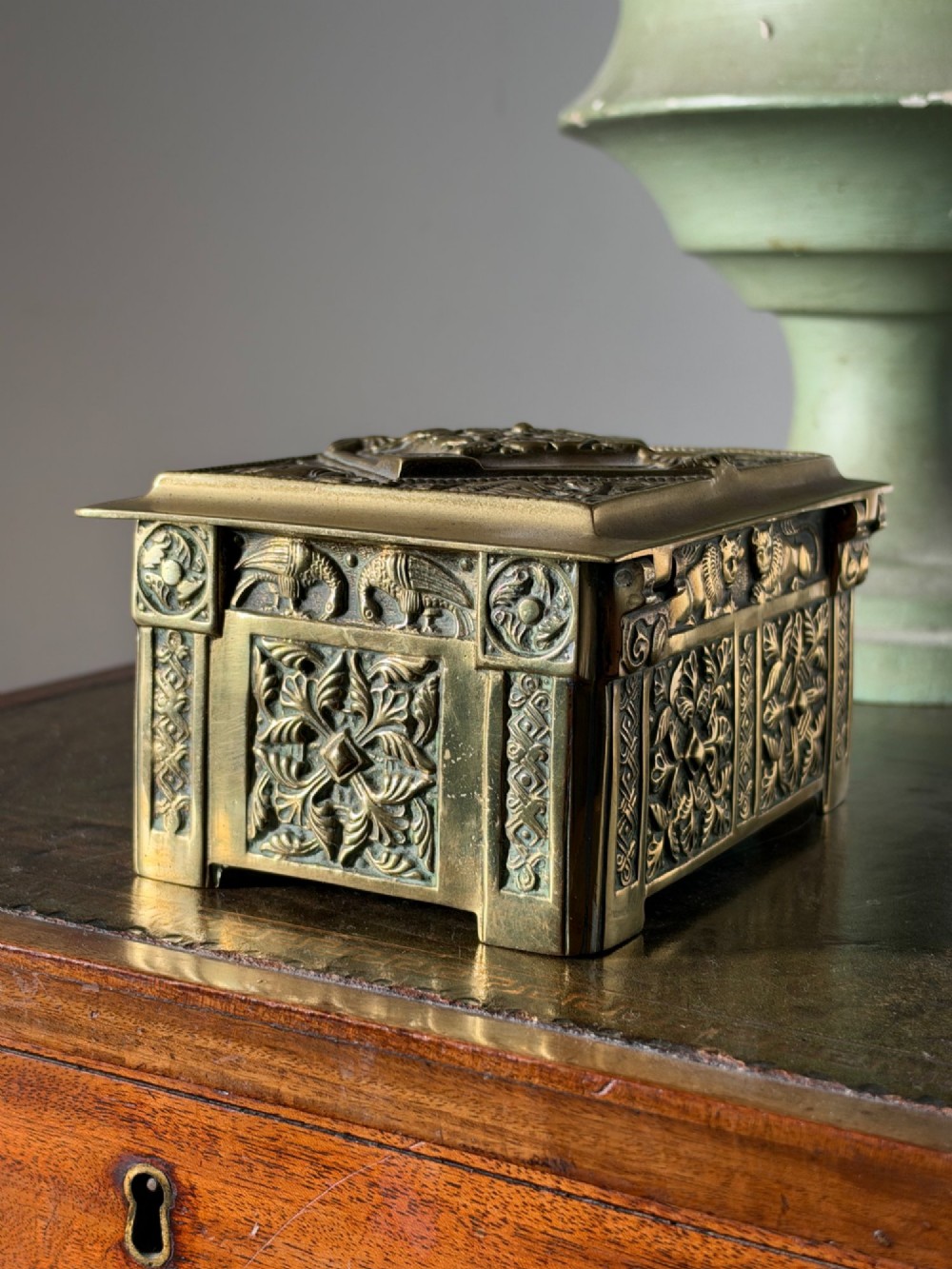A nineteenth-century rectangular cast brass casket featuring detailed relief ornamentation of animals, foliage, and geometric patterns. View III