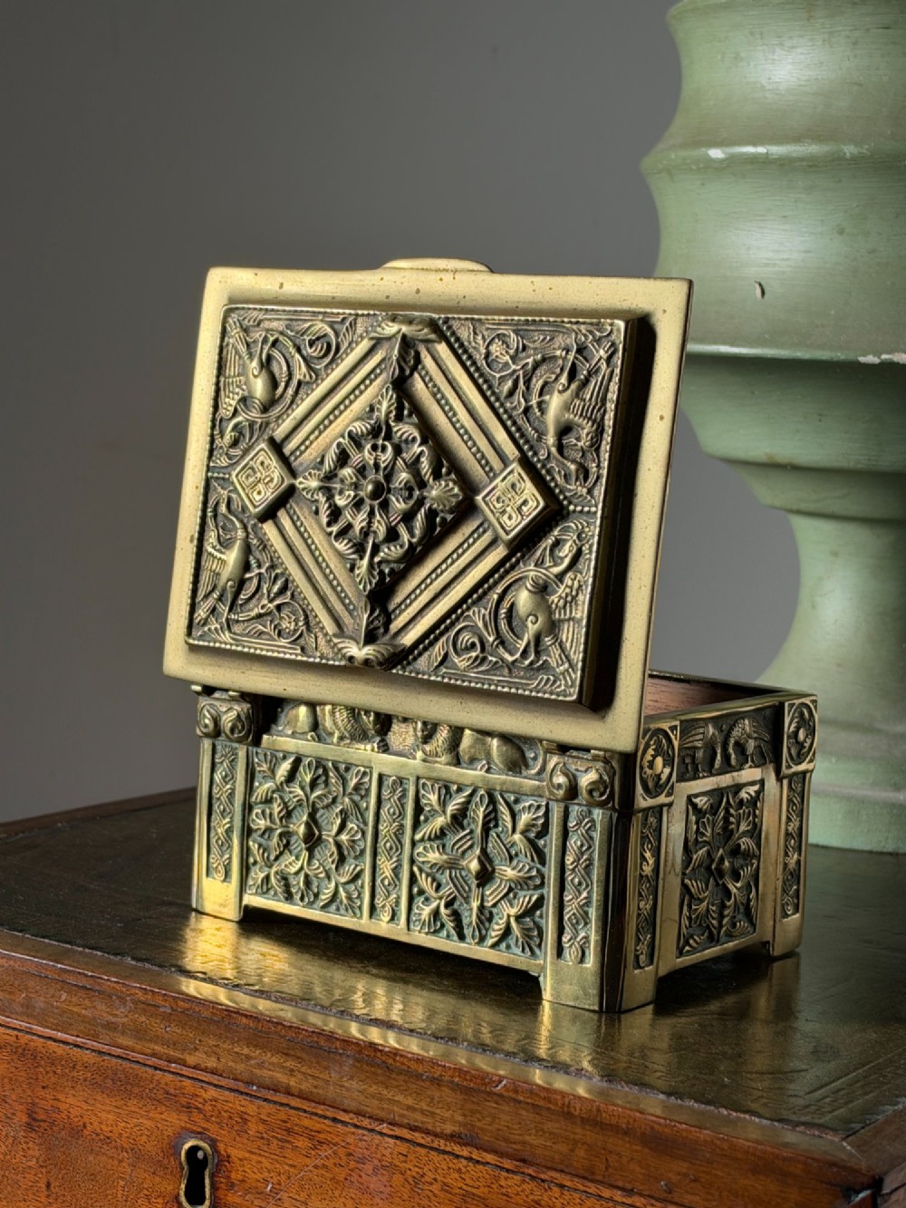 A nineteenth-century rectangular cast brass casket featuring detailed relief ornamentation of animals, foliage, and geometric patterns. View VI