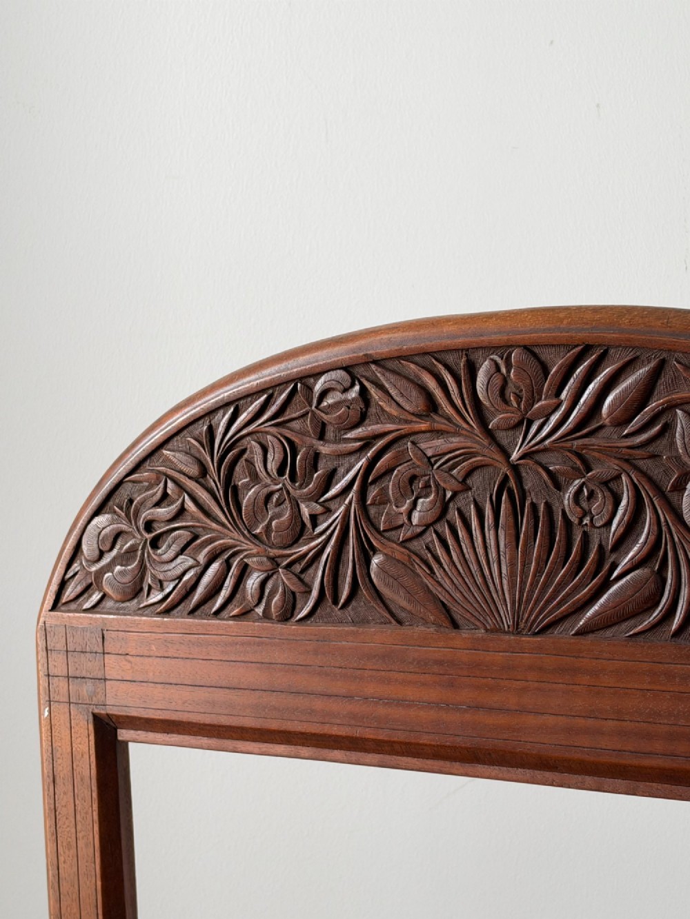 A freestanding Anglo-Indian carved walnut screen frame featuring an arched floral crest and splayed scrolled feet. View V