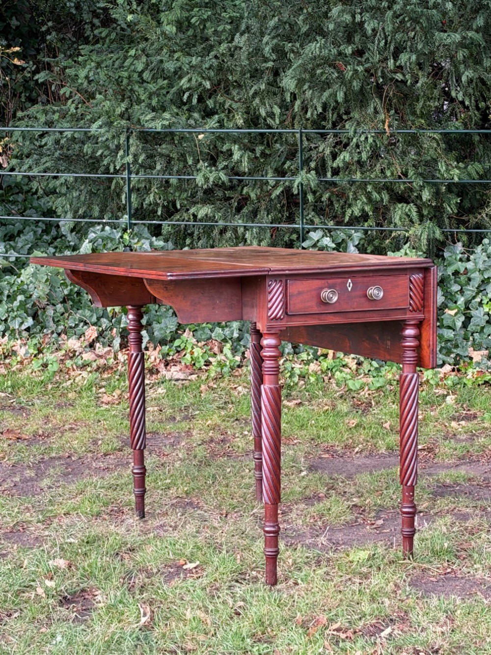 A George IV mahogany drop-leaf table featuring spiral turned legs, a single drawer with twin pull knobs, and two folding side leaves. View III