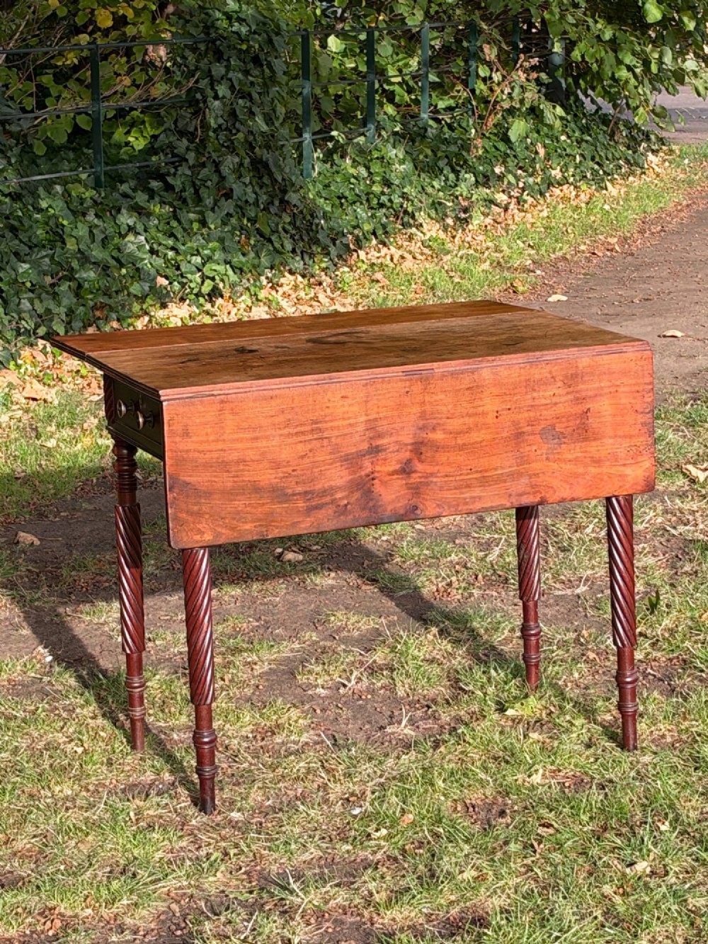 A George IV mahogany drop-leaf table featuring spiral turned legs, a single drawer with twin pull knobs, and two folding side leaves. View VI