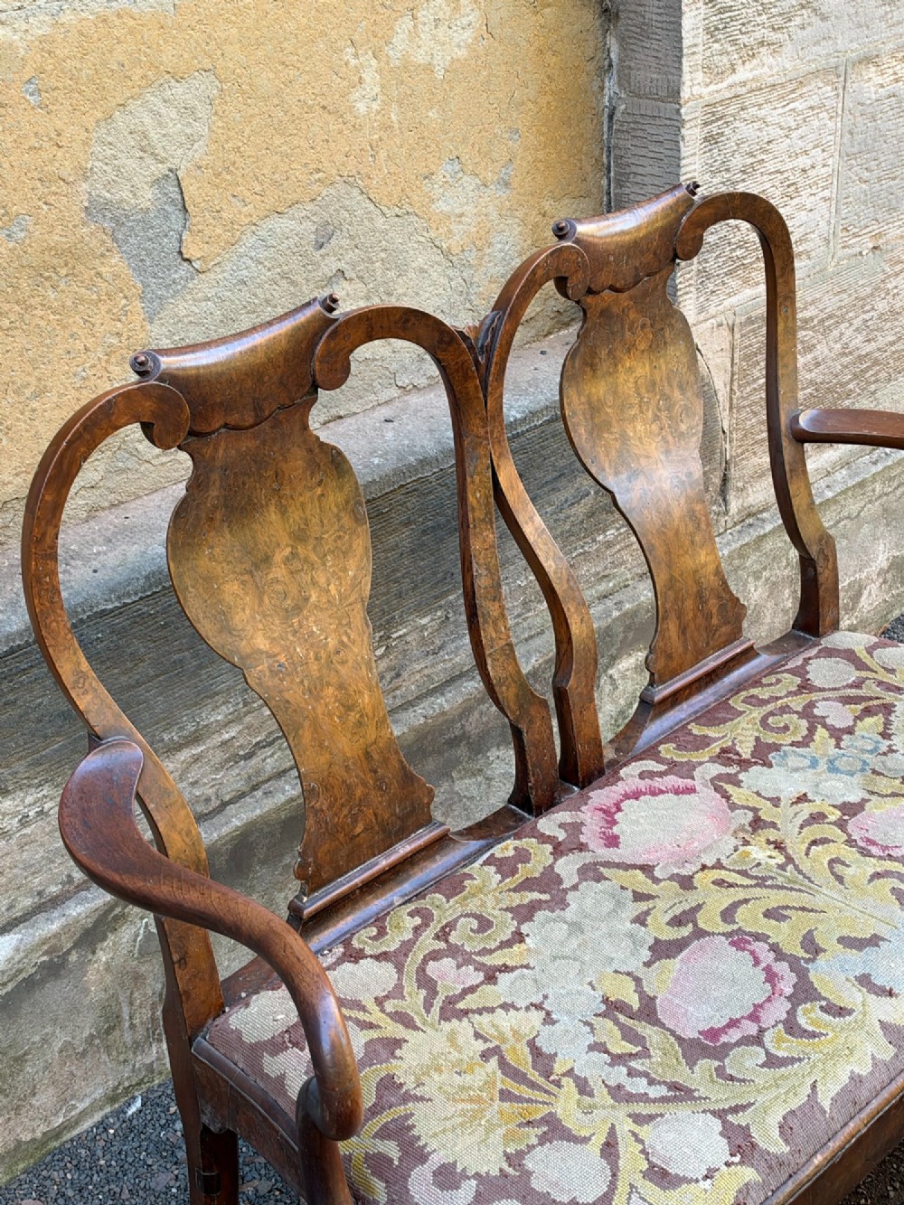 A late nineteenth-century George II style double chair-back settee in warm brown walnut and burr walnut with shepherd crook arms and an upholstered seat. View III