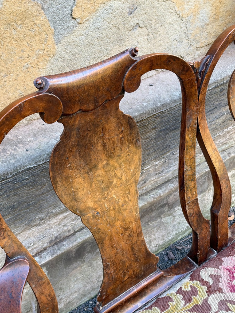 A late nineteenth-century George II style double chair-back settee in warm brown walnut and burr walnut with shepherd crook arms and an upholstered seat. View IV