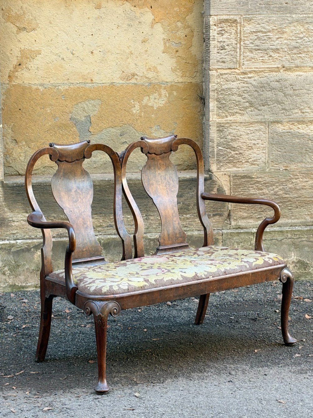A late nineteenth-century George II style double chair-back settee in warm brown walnut and burr walnut with shepherd crook arms and an upholstered seat. View VIII