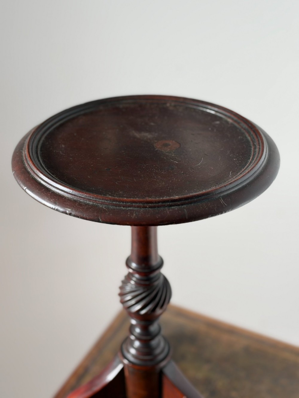 A late 19th-century George III style dark mahogany kettle stand with a circular dish top, spiral-carved baluster column, and tripod cabriole legs. View VII