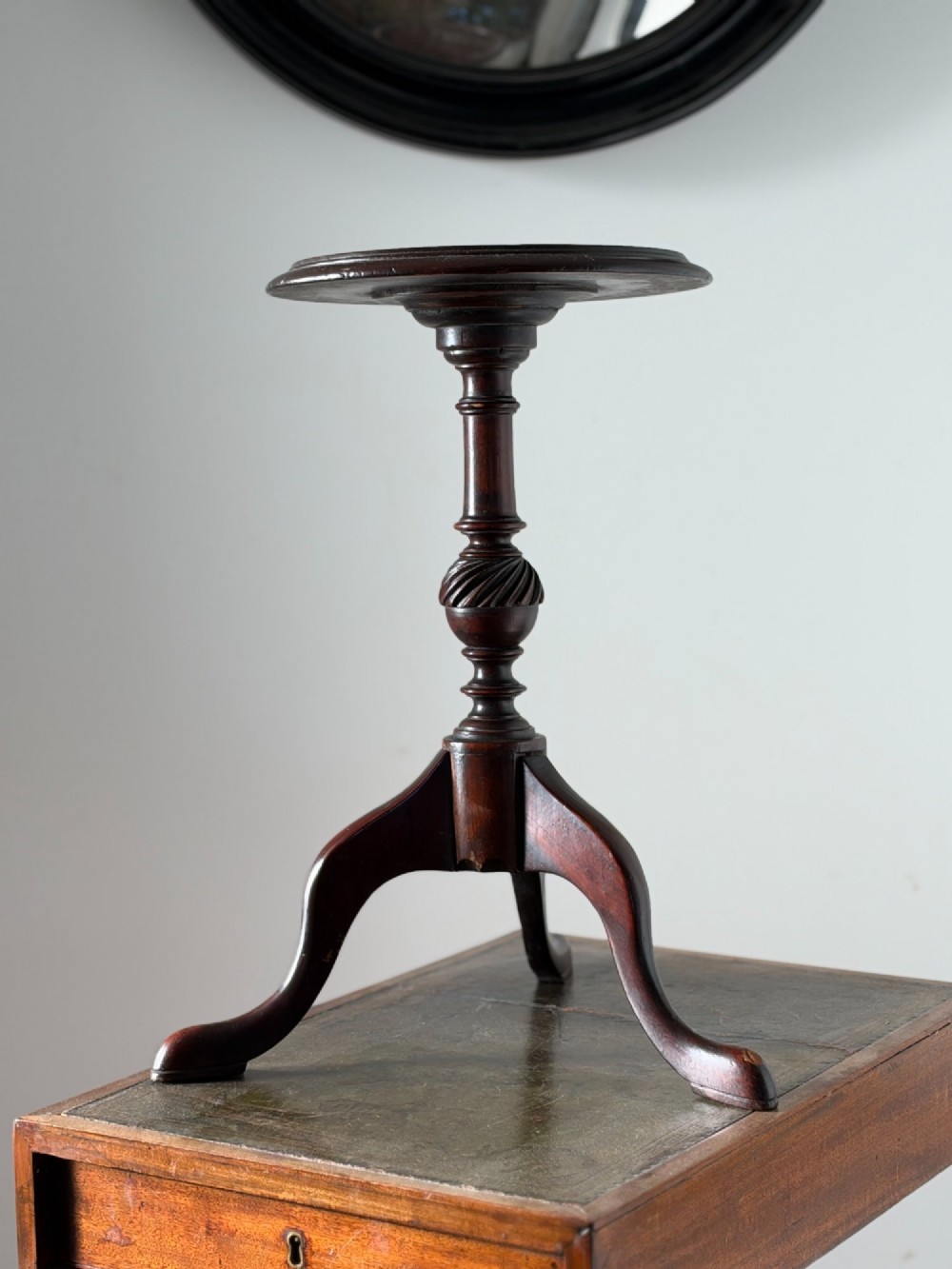 A late 19th-century George III style dark mahogany kettle stand with a circular dish top, spiral-carved baluster column, and tripod cabriole legs.