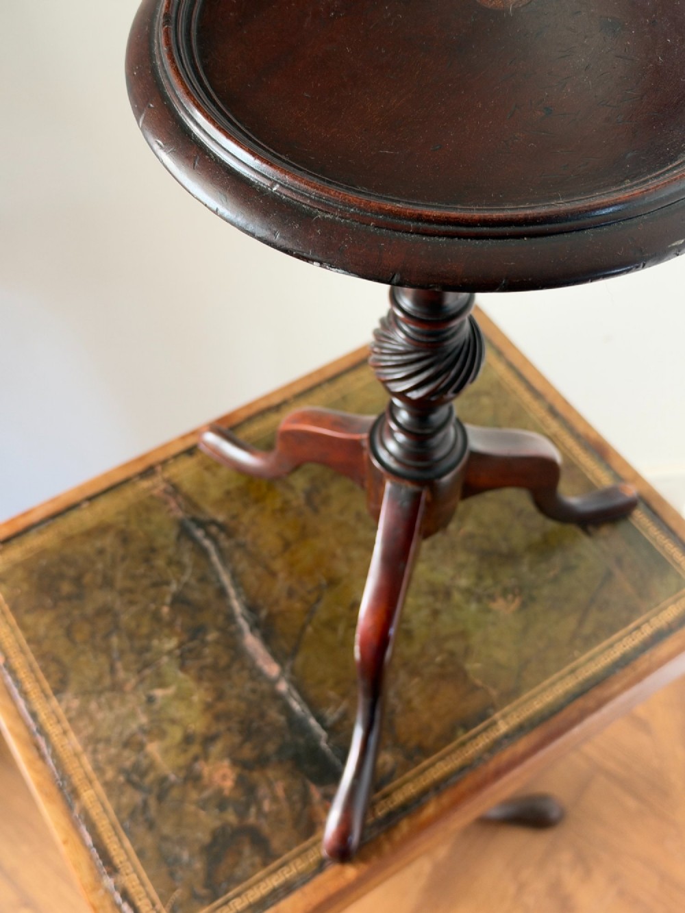 A late 19th-century George III style dark mahogany kettle stand with a circular dish top, spiral-carved baluster column, and tripod cabriole legs. View X