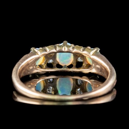 fig 1. An antique Victorian gold ring set with three oval cabochon opals and four small diamonds in a carved scroll gallery.