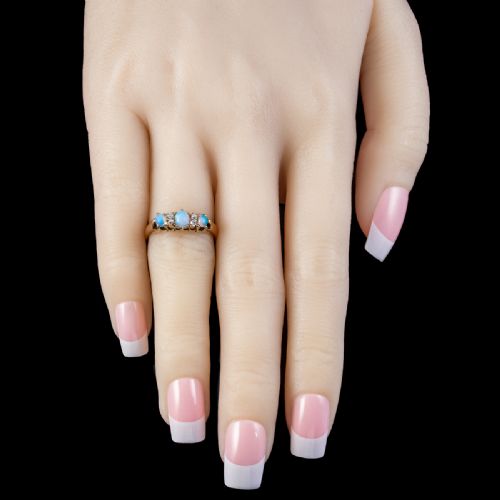 fig 3. An antique Victorian gold ring set with three oval cabochon opals and four small diamonds in a carved scroll gallery.