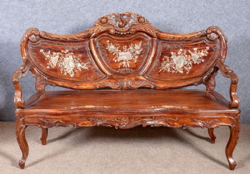 fig 1. A four-piece Chinese hardwood furniture suite featuring intricate mother-of-pearl floral inlays, comprising a settee, an armchair, a rectangular table, and a small side stool.