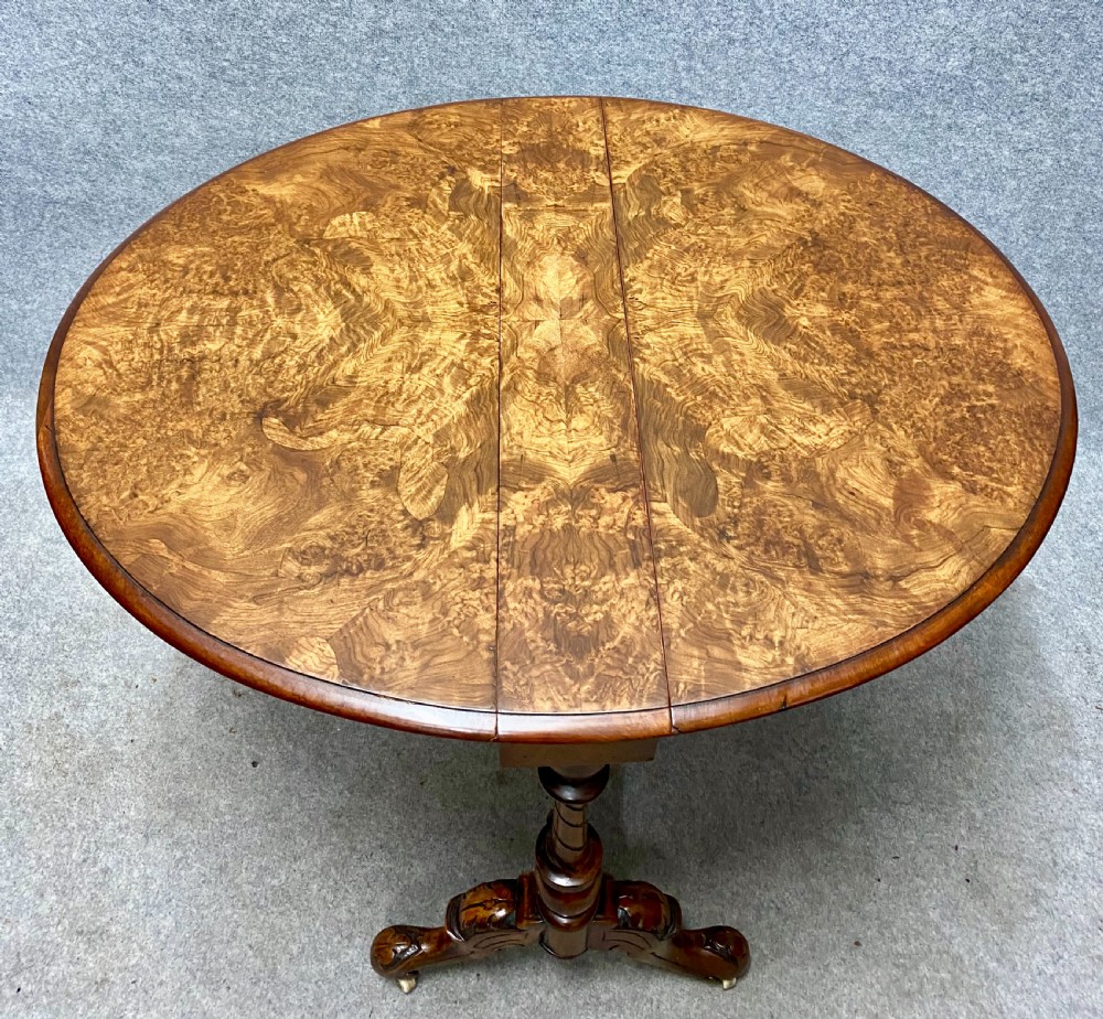 A Victorian burr walnut drop-leaf table featuring symmetrical figured grain, turned supports, spiral stretchers, and carved legs on castors. View III
